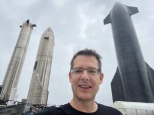 Photo of Dr Tim Parsons in front of a rocket